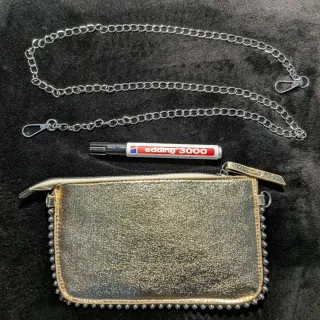 Bolso de mano dorado con cadena