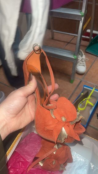 Zapatos de tacón naranja con flor dorada