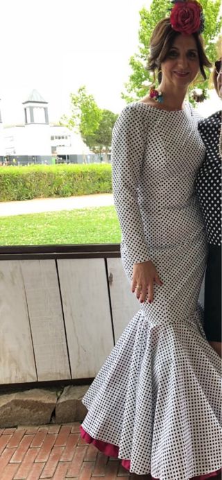 Traje de flamenca blanco, lunar negro y bajo rosa.