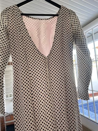 Traje de flamenca blanco, lunar negro y bajo rosa.