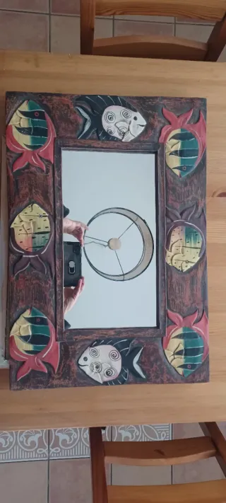 Espejo de madera con peces decorativos.