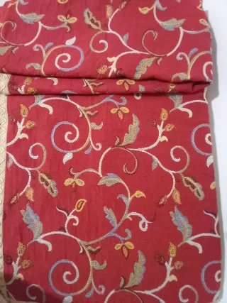 Copriletto rosso con decoro floreale.