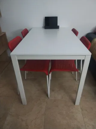 Mesa blanca con 4 sillas rojas