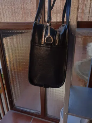 Bolso negro con accesorio de corazón