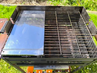 Barbacoa de carbón con mesas laterales