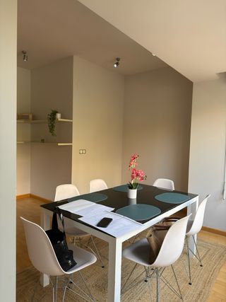 Mesa comedor negra y 6 sillas blancas.