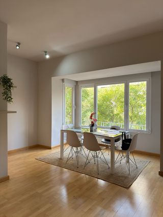 Mesa comedor negra y 6 sillas blancas.