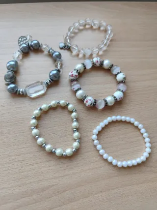 Pulseras blancas y plateadas