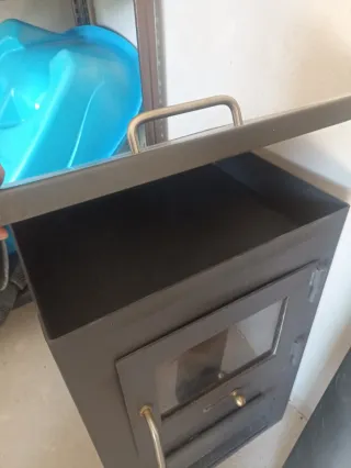 Estufa de leña metálica con puerta de cristal