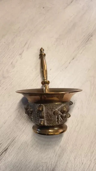 Mortero de bronce con mano