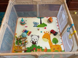 Parque infantil con alfombra de juegos y bolas.