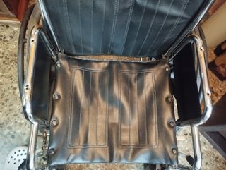 Silla de ruedas negra plegable.