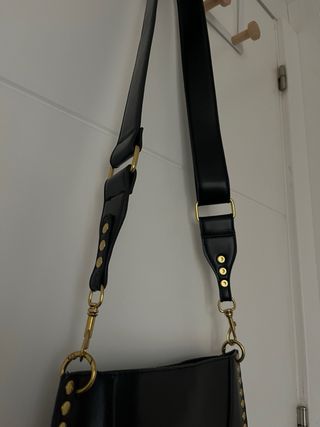 Bolso negro con tachuelas doradas