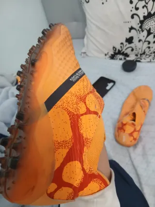 Botas de fútbol naranjas y rojas