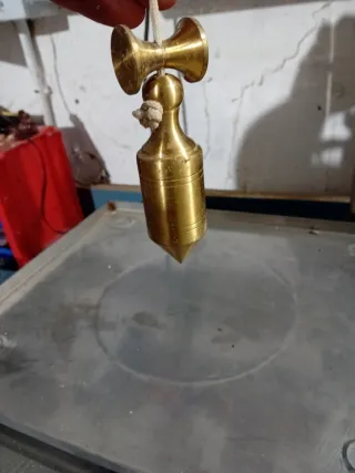 Plomada de metal dorada