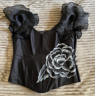 Vestido negro con volantes y flor