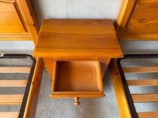 Mesita de noche de madera con cajón y armario.