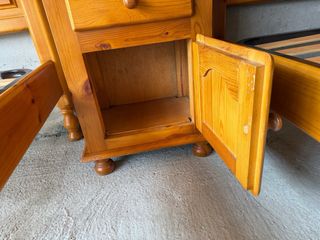 Mesita de noche de madera con cajón y armario.