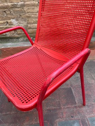 Sillas rojas metálicas y respaldo plástico