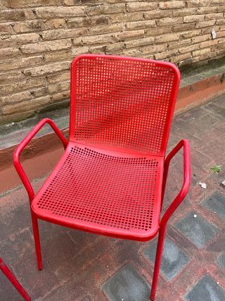 Sillas rojas metálicas y respaldo plástico