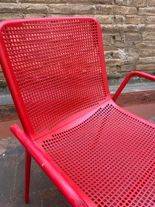 Sillas rojas metálicas y respaldo plástico
