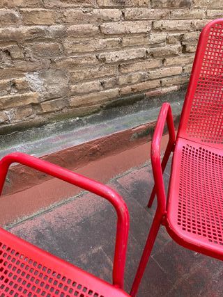 Sillas rojas metálicas y respaldo plástico