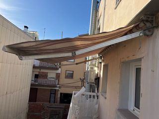 Toldo extensible manual beige y marrón