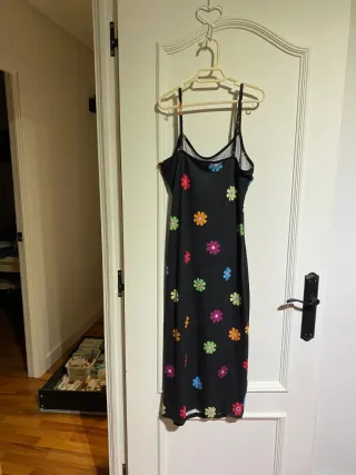 Vestido negro con flores multicolor.