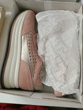 Zapatillas rosas con cremallera y cordones.