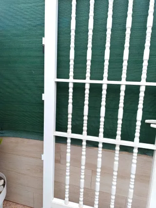 Puerta de aluminio blanca con barrotes