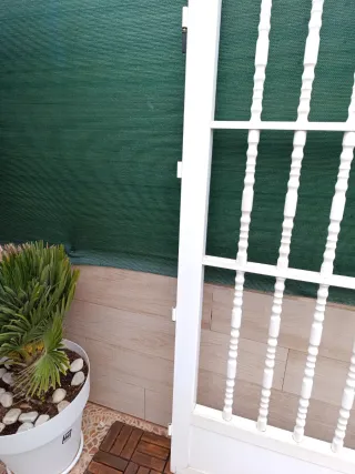 Puerta de aluminio blanca con barrotes