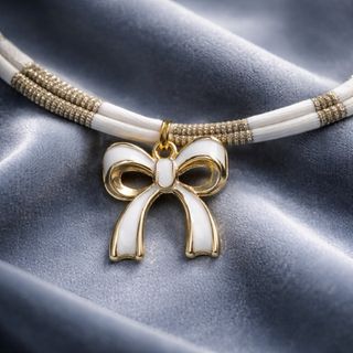 Collana a righe bianco e oro con ciondolo fiocco