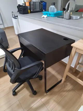 Escritorio negro y silla con ruedas