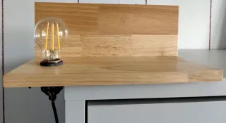 Mesilla de madera con lámpara integrada.