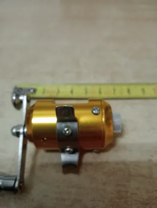 Carrete de pesca mini dorado