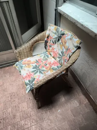 Sillón de mimbre con cojines florales