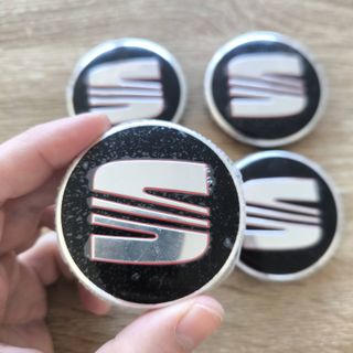 TAPABUJES SEAT 56mm NEGROS - EMBLEMA LLANTAS SEAT