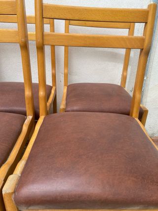 Sillas de madera con asiento polipiel marrón.