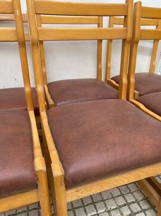 Sillas de madera con asiento polipiel marrón.