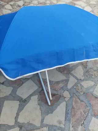 Sombrilla de playa y piscina azul