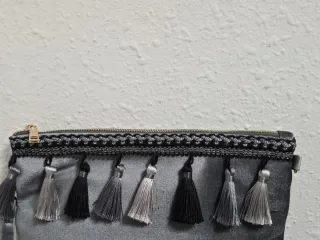 Bolso de mano gris con borlones