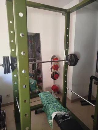 Rack de gimnasio con banco y barras y discos