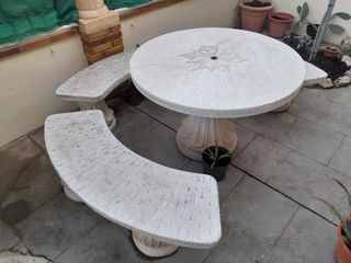 Mesa redonda de piedra con 3 bancos