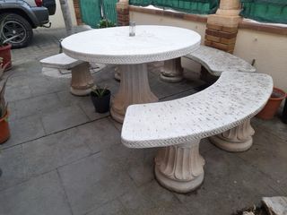 Mesa redonda de piedra con 3 bancos
