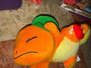 Peluche Pokemon Charmander debajo de la oja