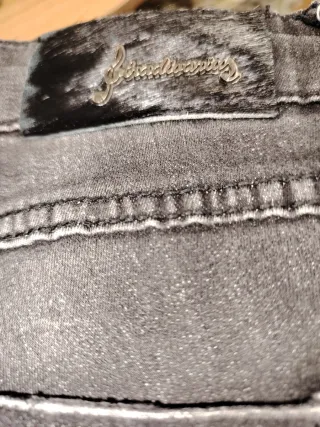 Pantalón tejano desgastado con tachuelas