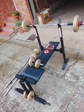 Banco de pesas con discos y barras