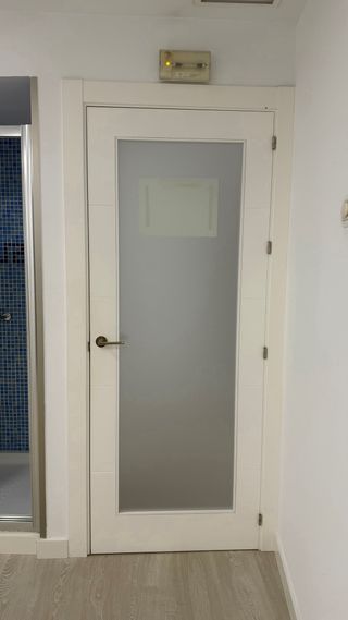 Puerta blanca lacada con cristal translúcido.