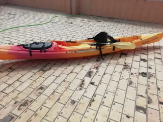 Kayak océankayak naranja y rojo con remo y asiento
