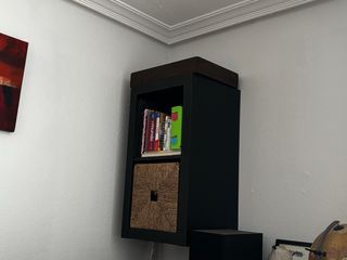 Estantería de pared negra y marron, forma de cubo.